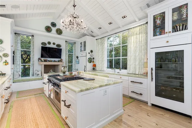 a open kitchen with stainless steel appliances granite countertop a stove and a large window