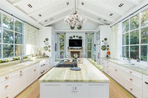 a bathroom with a granite countertop sink a large mirror and a bathtub next to a window