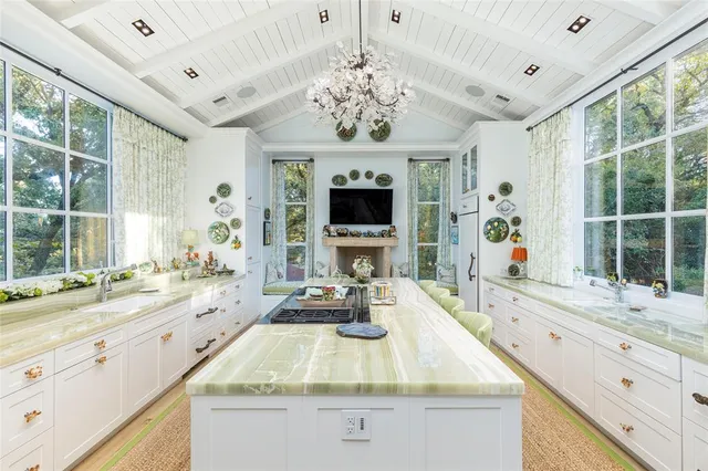 a bathroom with a granite countertop sink a large mirror and a bathtub next to a window