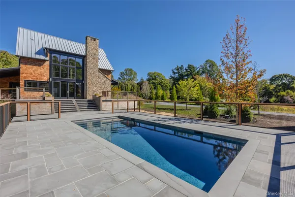 a swimming pool with outdoor seating and yard