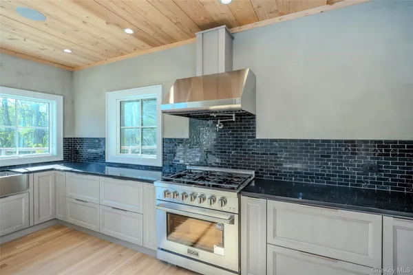 a kitchen with granite countertop a stove sink and cabinets