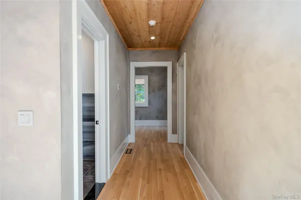 a view of a hallway with wooden floor
