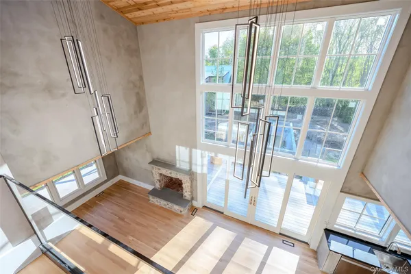 a view of a living room with a floor to ceiling window and wooden floor