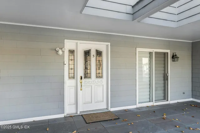 a kitchen with stainless steel appliances white cabinets a sink a stove a dining table and chairs