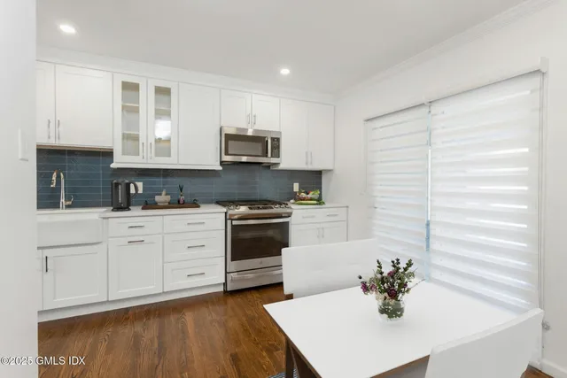a kitchen with stainless steel appliances granite countertop grey cabinets a stove a sink and dishwasher