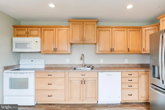 a kitchen with granite countertop white cabinets and white appliances