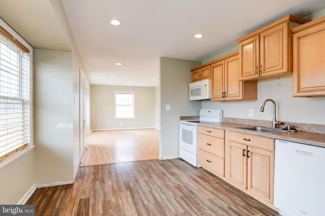 a large kitchen with granite countertop a sink window and cabinets