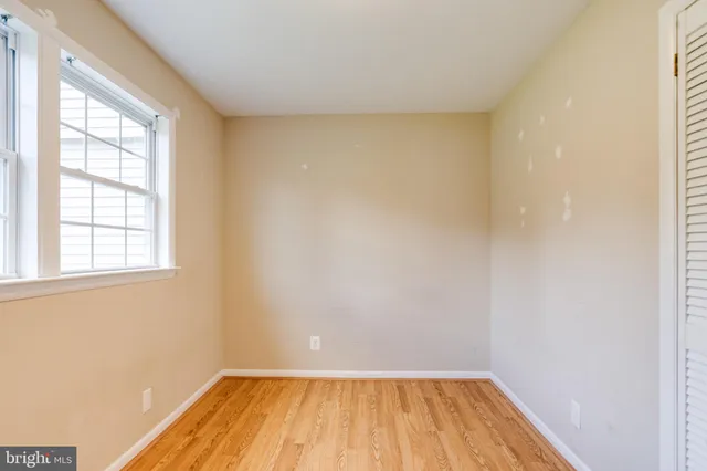 a view of a room with wooden floor and small window