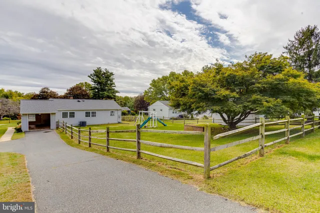 a view of house with yard and furniture