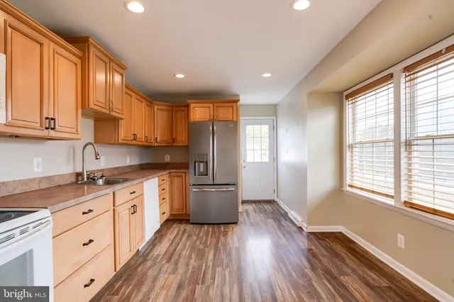 a kitchen with granite countertop wooden floors and white cabinets