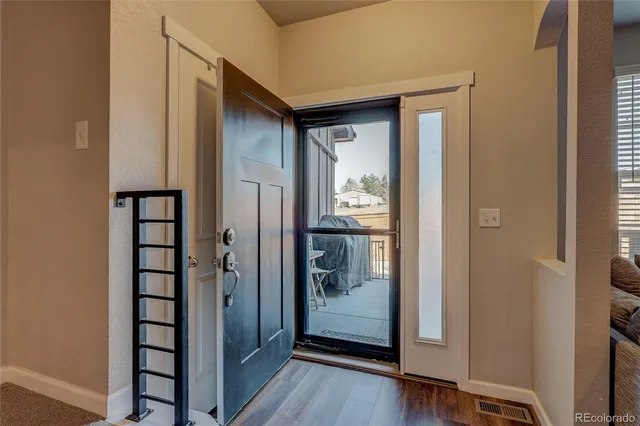 a view of a hallway with wooden floor and dining room