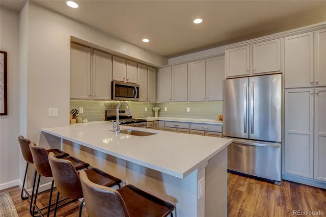 a kitchen with a refrigerator a stove a microwave and island with wooden floor