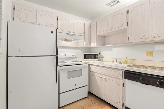 a kitchen with granite countertop white cabinets and white appliances