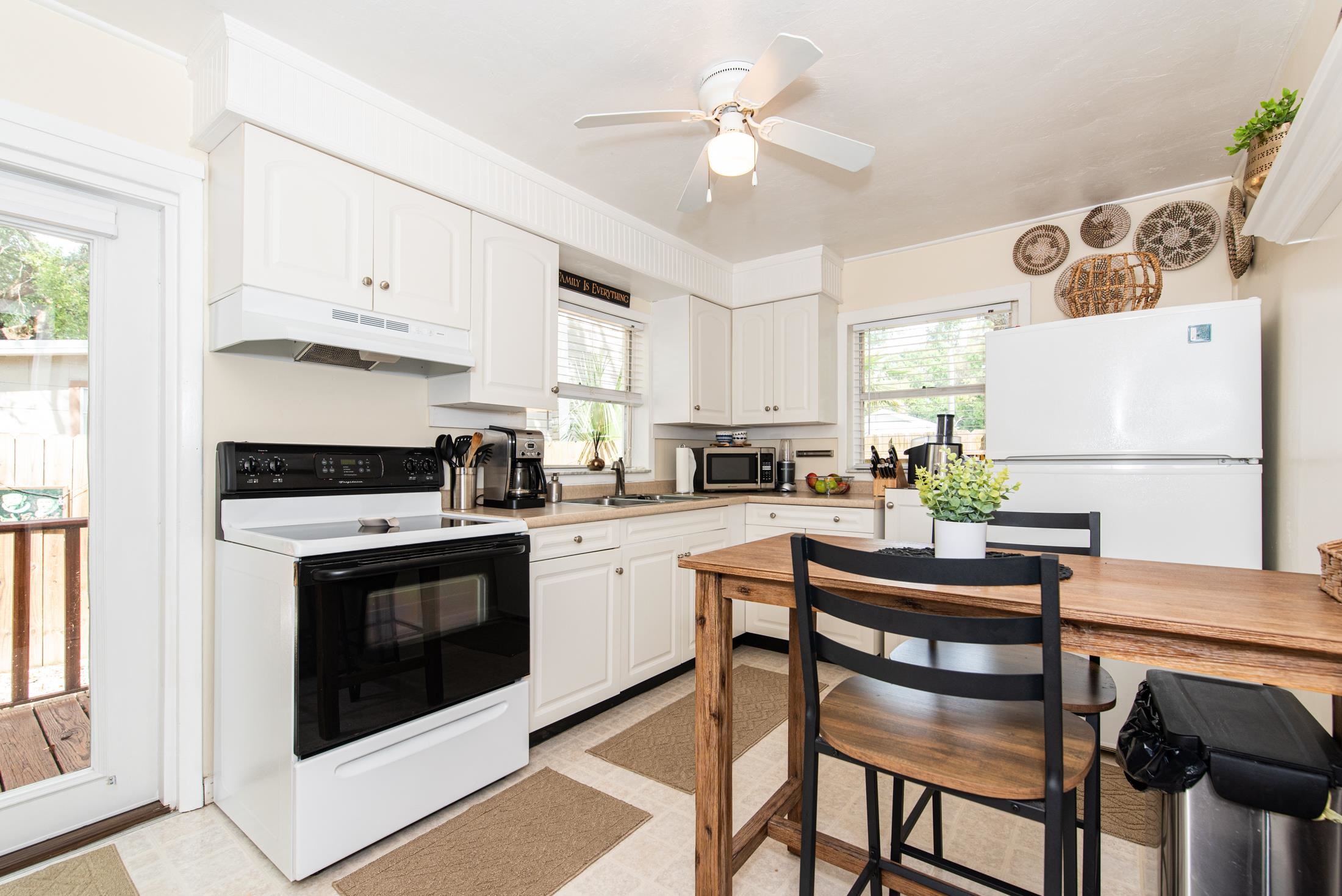 132 Oneida Street St. Augustine, FL 32084 - Photo 8 of 36 a kitchen with a white cabinets and chairs