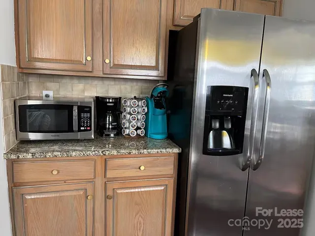 a kitchen with granite countertop a refrigerator and a sink