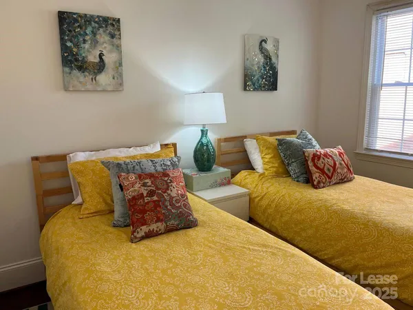 a bed sitting in a bedroom next to a window