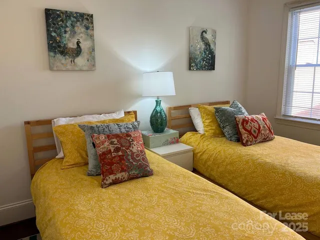 a bed sitting in a bedroom next to a window