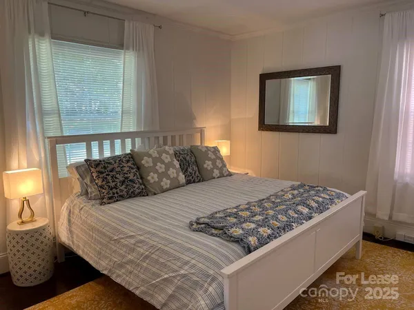 a bed sitting in a bedroom next to a window