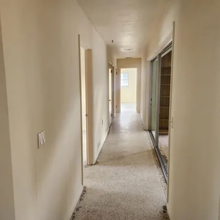 a view of a hallway with wooden floor and closet