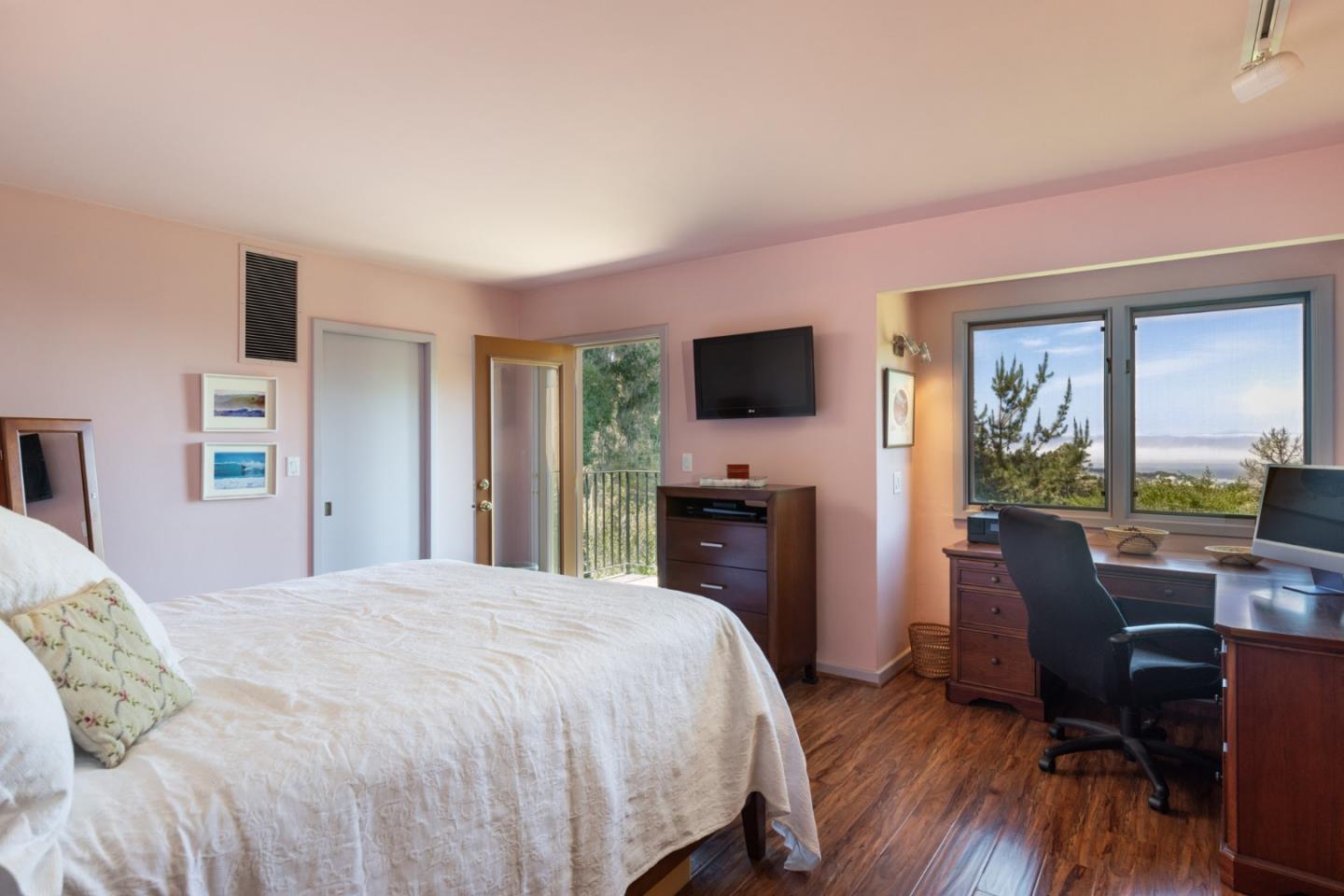 540 Aguajito Road Carmel, CA 93923 - Photo 22 of 32 a spacious bedroom with a bed and a flat screen tv