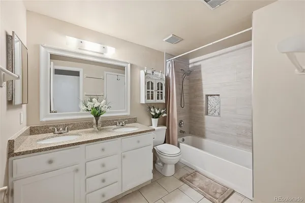 a bathroom with a granite countertop sink a toilet and shower