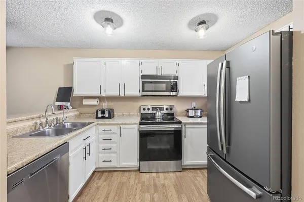 a kitchen with stainless steel appliances granite countertop a refrigerator stove and sink