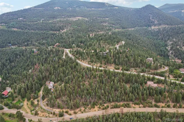 a view of a dry yard with trees and mountains