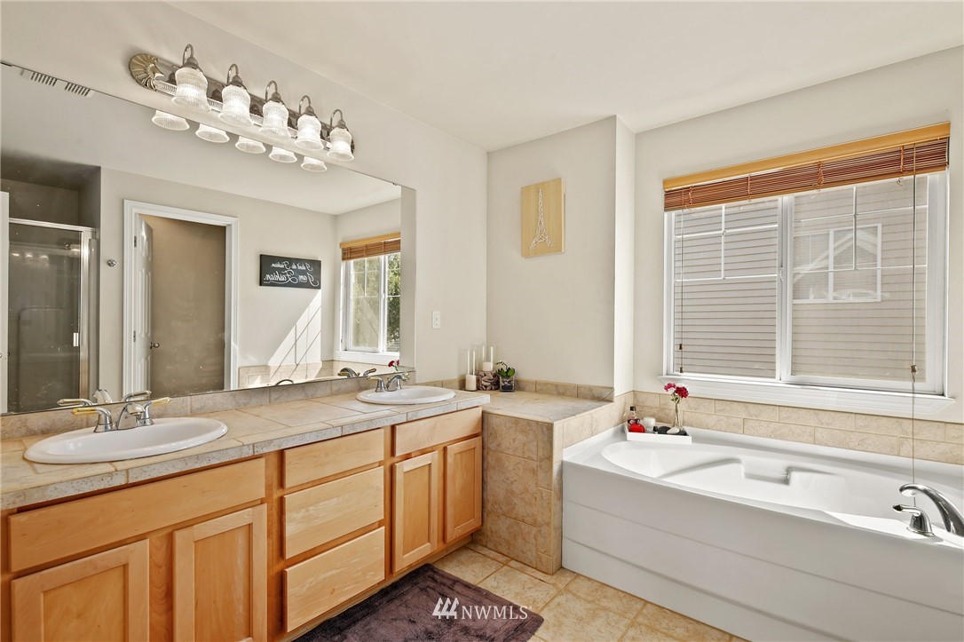 322 South 21st Street Renton, WA 98055 - Photo 18 of 29 a bathroom with a tub a sink double vanity and a mirror