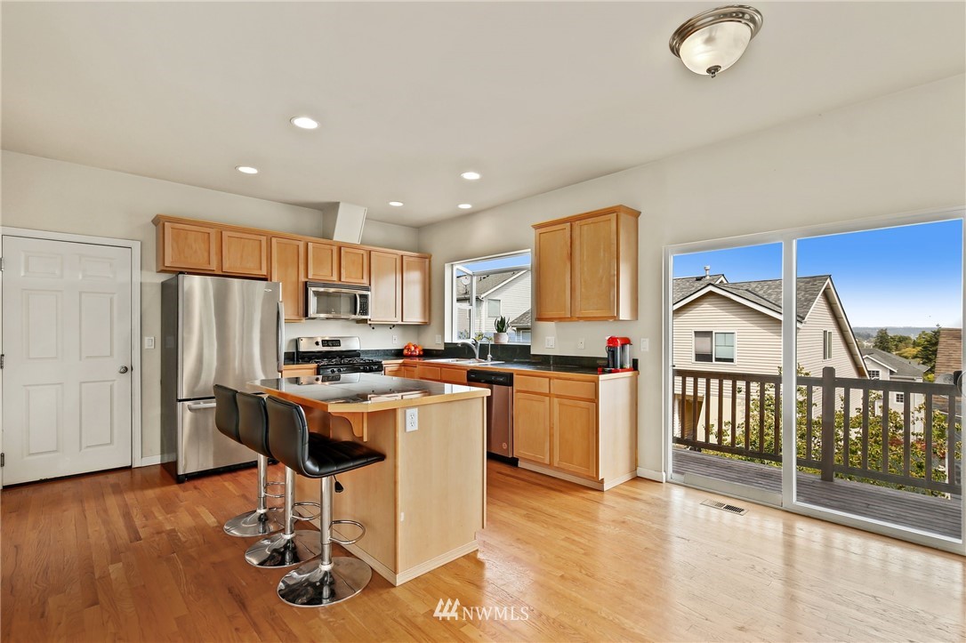 322 South 21st Street Renton, WA 98055 - Photo 8 of 29 a kitchen with a refrigerator a stove top oven a sink dishwasher and white cabinets with wooden floor