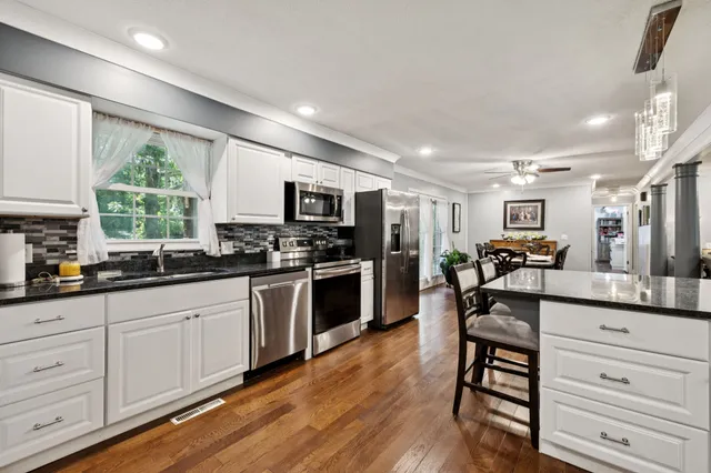 a bedroom with a bed chandelier and a window