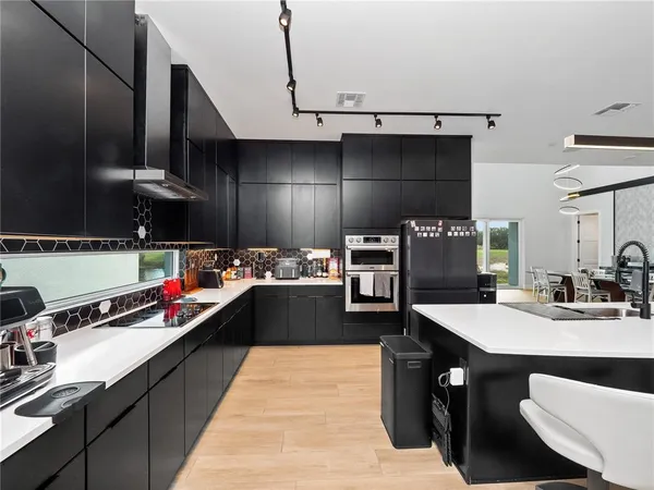 a kitchen with stainless steel appliances granite countertop a sink stove and refrigerator