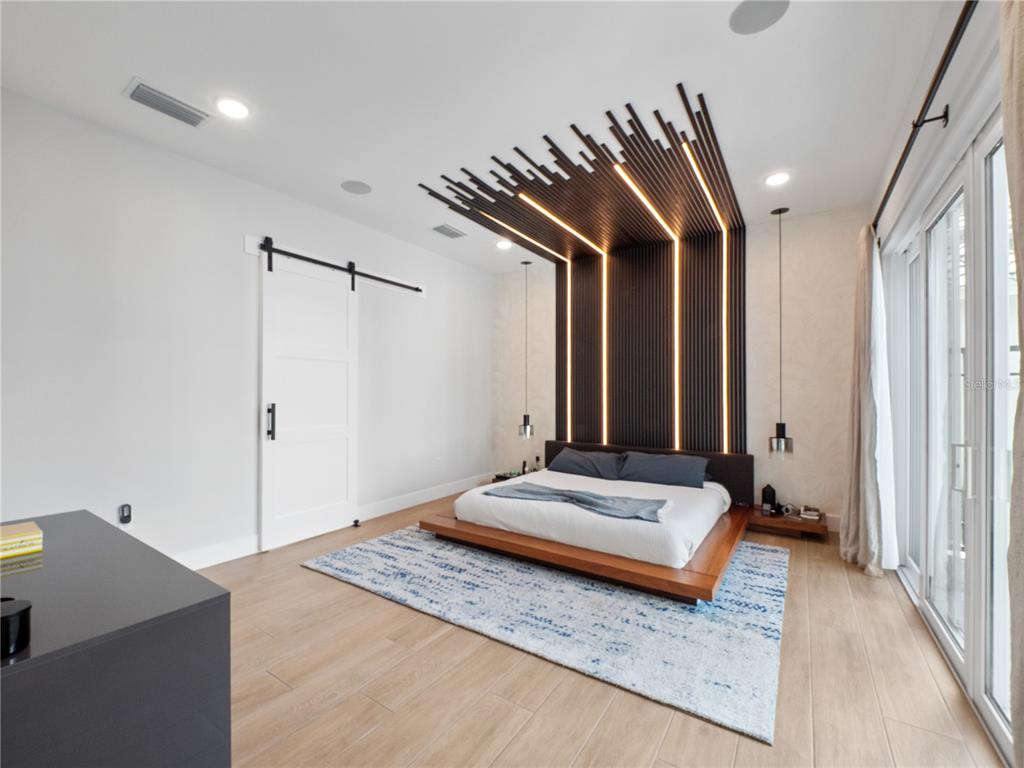 239 Hampton Loop Davenport, FL 33837 - Photo 21 of 43 a spacious bedroom with a bed and a chandelier