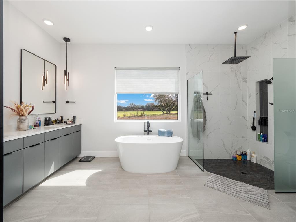 239 Hampton Loop Davenport, FL 33837 - Photo 26 of 43 a spacious bathroom with a bathtub sink and mirror