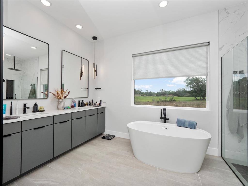 239 Hampton Loop Davenport, FL 33837 - Photo 27 of 43 a bathroom with a double vanity sink tub and mirror