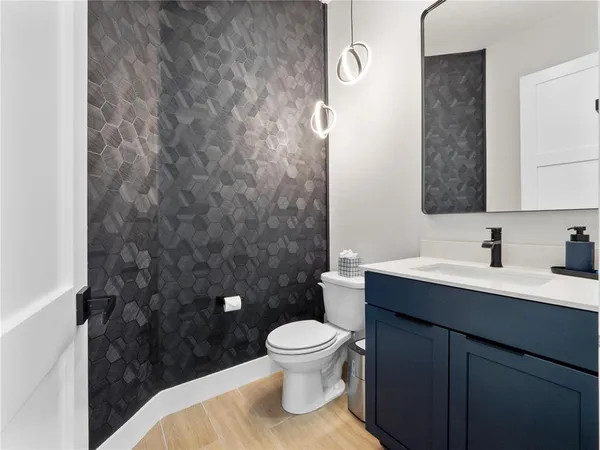 a bathroom with a granite countertop toilet a sink and a mirror