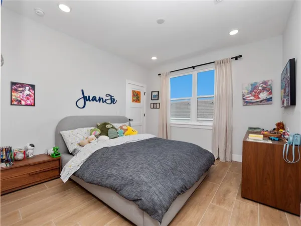 a bedroom with a bed and wooden floor
