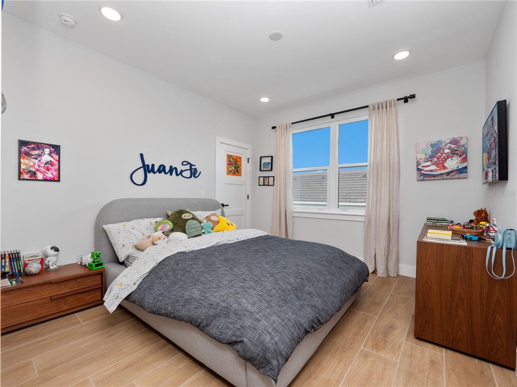 239 Hampton Loop Davenport, FL 33837 - Photo 33 of 43 a bedroom with a bed and wooden floor