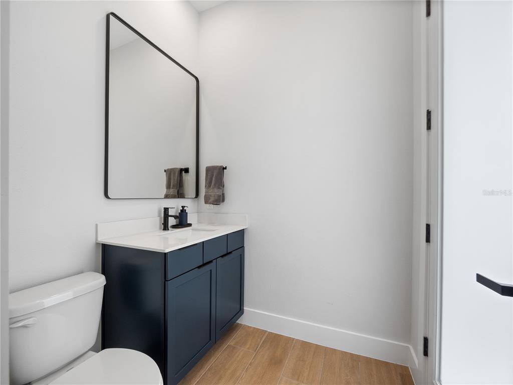 239 Hampton Loop Davenport, FL 33837 - Photo 39 of 43 a bathroom with a toilet sink vanity and mirror