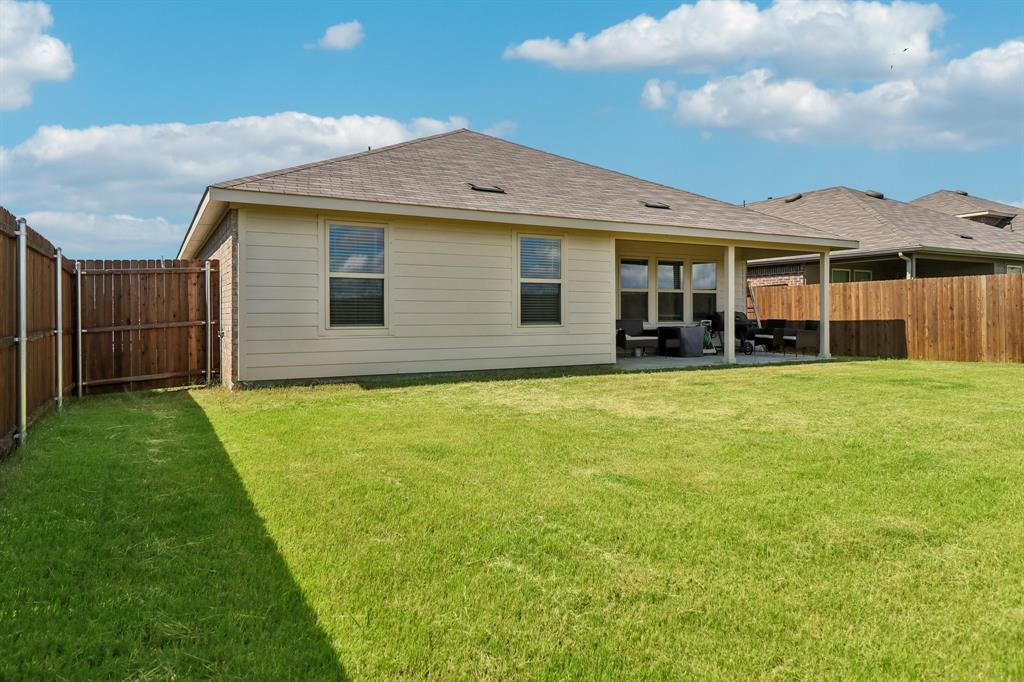1453 Millstead Rill Road Caddo Mills, TX 75135 - Photo 39 of 40 Expansive backyard featuring a manicured lawn, full wood privacy fencing, and a covered patio