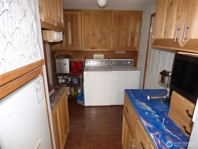 a view of a kitchen with fridge and wooden floor