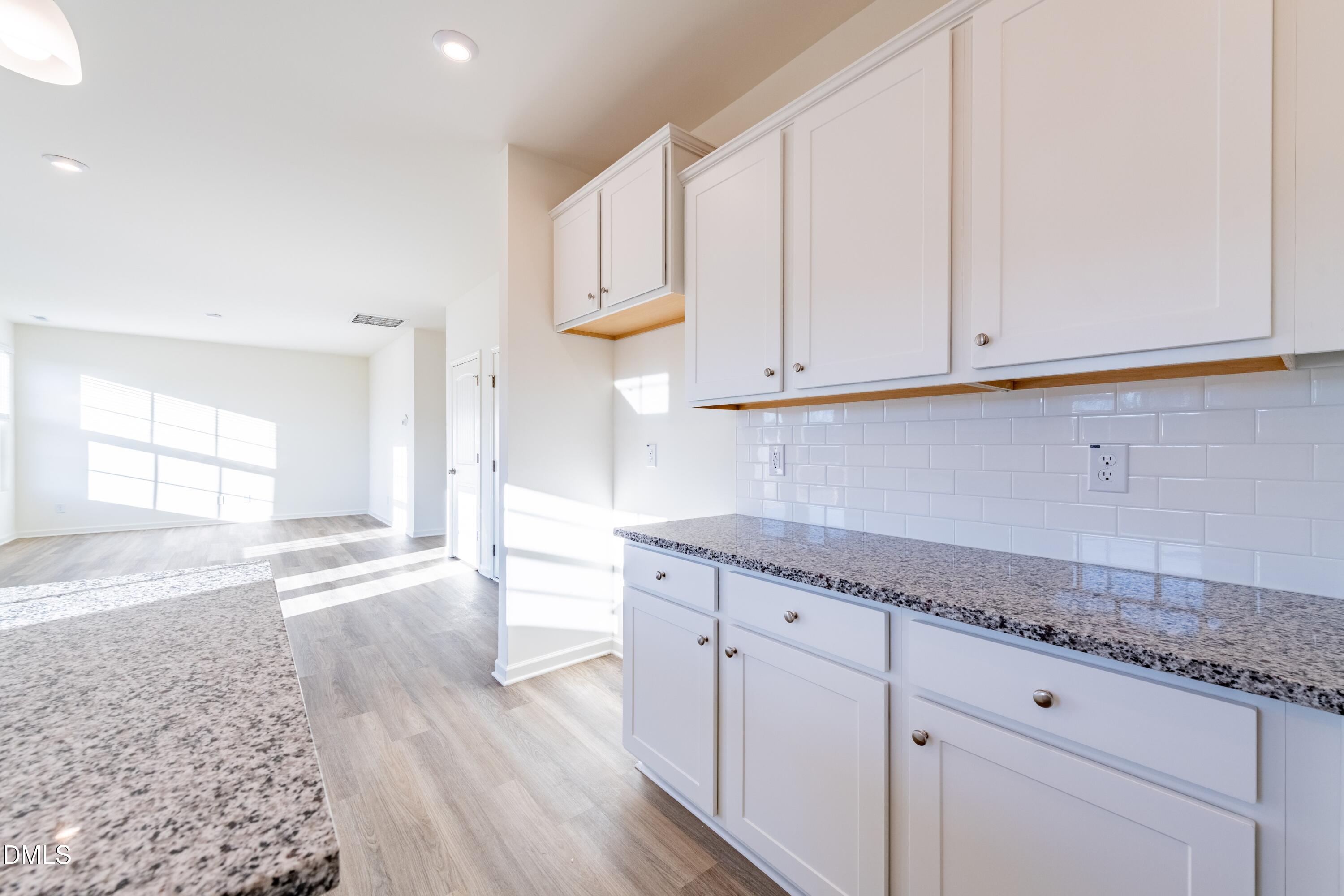 55 Fern Ridge Drive, Unit 1 Cameron, NC 28326 - Photo 15 of 42 a kitchen with granite countertop white cabinets and a sink