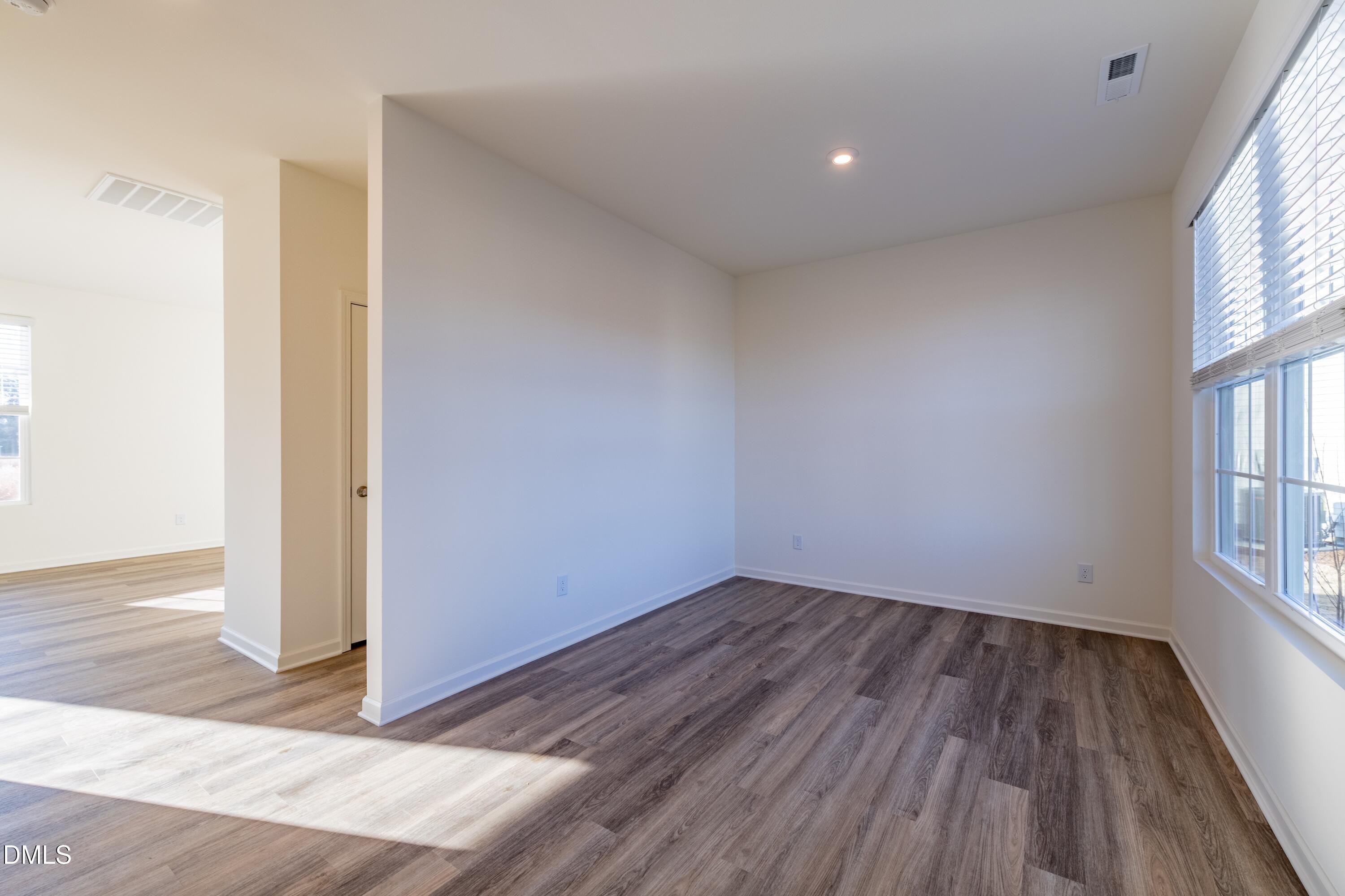 55 Fern Ridge Drive, Unit 1 Cameron, NC 28326 - Photo 3 of 42 an empty room with wooden floor and windows