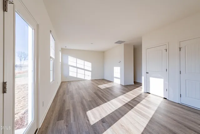 a view of a room with wooden floor and window