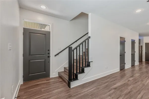 a view of a hallway with wooden floor and staircase