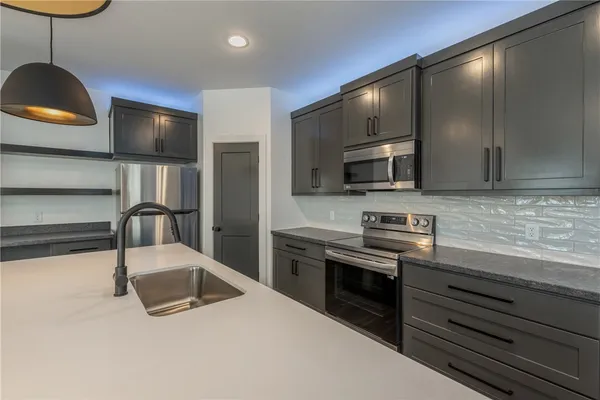 a kitchen with stainless steel appliances a stove a refrigerator and microwave