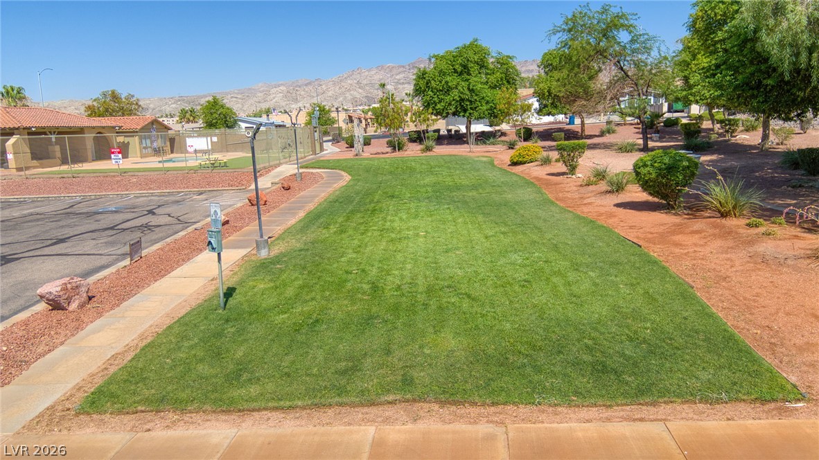 3189 Del Monte Street Laughlin, NV 89029 - Photo 25 of 32 A vibrant green lawn and well-maintained landscaping complement the peaceful neighborhood setting.