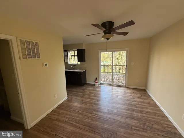a view of a livingroom with wooden floor and a ceiling fan