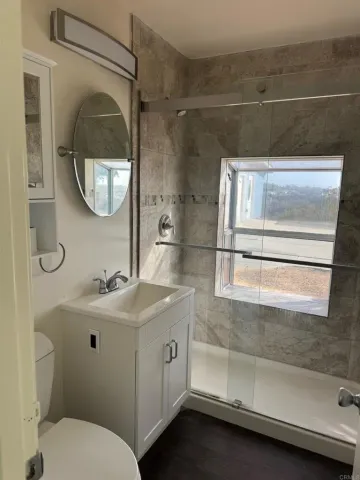 a bathroom with a sink and mirror with bathtub