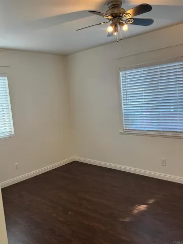 a view of a room with wooden floor and ceiling fan