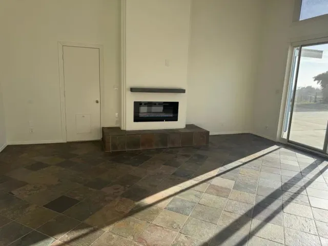 an empty room with wooden floor and fireplace